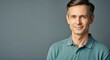 © Postmodern Studio - Confident caucasian mature male in green polo against gray background
