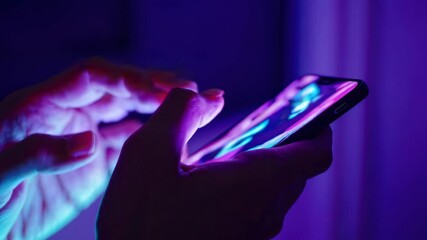 Poster - Close-up of hands interacting with smartphone displaying vibrant colorful interface in dark environment neon lit environment, seamless loop