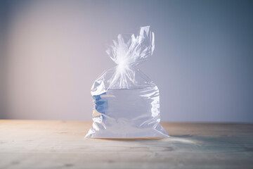 Poster - Transparent Plastic Bag Filled with Water Against a Softly Lit Background
