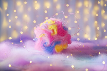Poster - Colorful Fluffy Wool Ball on Soft Background with Twinkling Fairy Lights