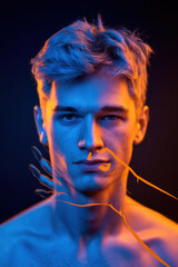 Poster - Intense Portrait of a Young Man with Artistic Overlay of Hands in Blue and Orange Lighting
