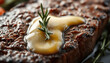 © agil - Close-up of a steak cooked to perfection with rosemary and melting butter.