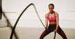 © peopleimages.com - Fitness, outdoor and woman with battle ropes for intense training, workout or health. Muscle, female bodybuilder and equipment for strength exercise, fast and motion blur for cardio challenge in city