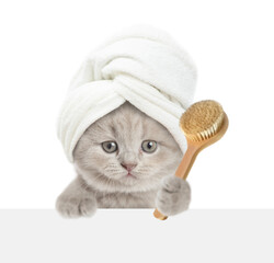 Fototapete - Cute kitten with towel on it head looks above blank white banner and holds shower brush. isolated on white background