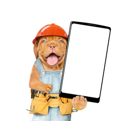 Aufkleber - Funny Mastiff puppy worker wearing hardhat and overalls with toolbelt shows big smartphone with white blank screen in it paw.  Isolated on white background