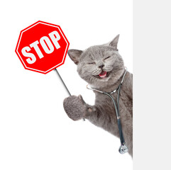 Poster - Happy cat dressed like a doctor with stethoscope on his neck looks from behind blank white banner and shows stop sign. isolated on white background