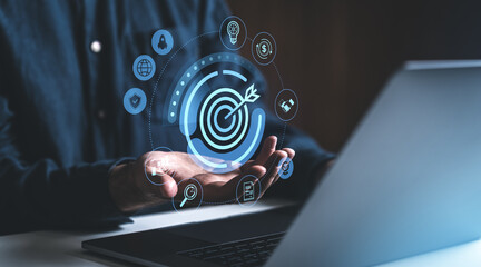 Poster - Businessman holding digital target icon with business strategy symbols.