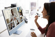 © fizkes - Young Latin manager woman speaking to multiethnic distant coworkers, freelance business partners on video conference call, speaking at mic of headset, looking at computer screen with headshots