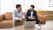 © fizkes - Two multiethnic men colleagues discuss joint online project, sit on sofa in office share problem solution vision, explain ideas and thoughts at workplace. Apprenticeship, opinion exchange, business