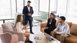 © fizkes - Four multiethnic teammates, met in coworking space to solve business-related matters, discuss performance of joint project or new business opportunity, exploring potential partnerships or cooperation