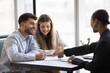 © fizkes - Happy couple engaged in conversation with advisor, realtor, or financial consultant, review agreement details, ready to sign contract, get professional services, feel satisfied with bank loan approval