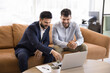 © fizkes - Two multiethnic businessmen sit in coworking space engaged in collaborative discussion using laptop, reviewing documents, presentations, brainstorm business matters in friendly, productive atmosphere