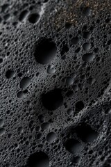 Poster - A close-up view of a black surface featuring multiple holes