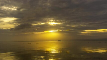 Wall Mural - sunset over calm waters creates a serene atmosphere with golden reflections and dramatic clouds, tim