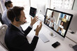 © fizkes - Focused contact center manager man in headset talking to diverse group of colleagues, partners on video conference chat, speaking at computer monitor, using technology for online meeting