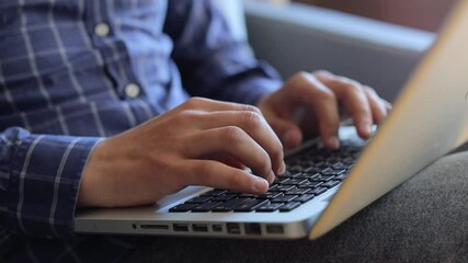 Concentrated male programmer typing rapidly on laptop keyboard, demonstrating deep professional focus while working on complex software development project


