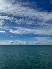 Wall Mural - beautiful cloudy sky over calm blue sea