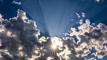 Poster - Sun shining through dramatic clouds in vibrant blue sky, radiant nature scene