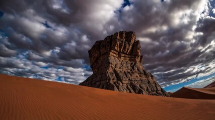Wall Mural - Dramatic desert rock formation under cloudy sky, remote and serene. Nature exploration.