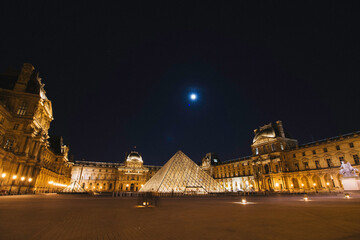 night cityscape panorama of louvre museum palace in paris, france