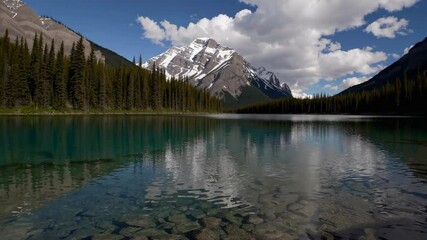 Wall Mural - Majestic mountain with snowy peak reflected in clear lake under blue sky