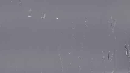 Poster - Blurry window with streaks of water on it. The window is covered in a thin layer of water, and the streaks are visible on the glass