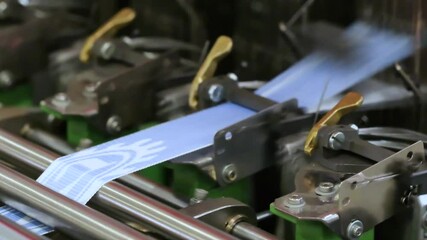 Poster - Machine is making blue fabric. The machine has a green handle