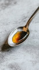 Poster - A close up photograph showing honey in a silver spoon