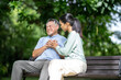 © Wanwajee - A daughter helping her father, old elderly sick senior Asian man got heart attack  at park. Health problem. Retired old man chest pain outdoor. Life and insurance concept.