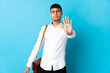 © luismolinero - Young business Colombian man isolated on blue background making stop gesture
