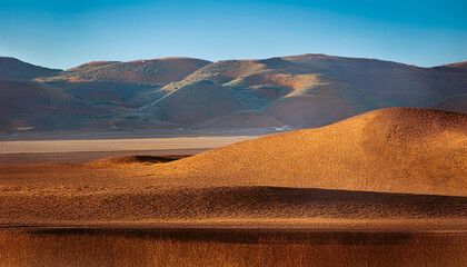 Poster - Landscape of rust-colored hills under a vibrant blue sky at golden hour