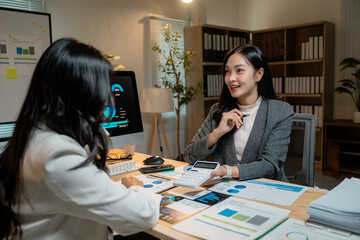 Fototapete - Asian businesswomen discussing and working with financial charts at office desk