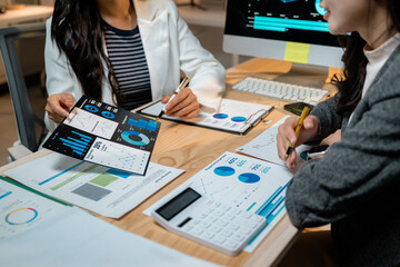 Poster - Businesswomen analyzing financial charts and graphs at office desk