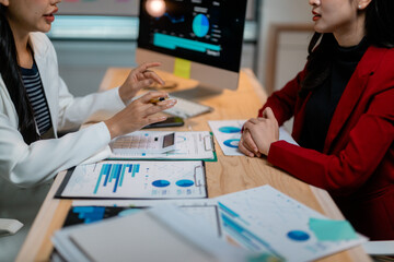 Poster - Businesswomen discussing marketing strategy using charts and graphs on computer and documents