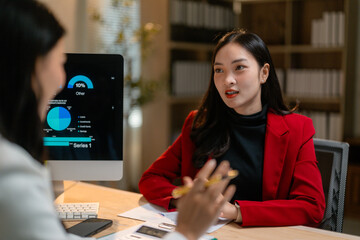 Poster - Businesswomen discussing financial charts and graphs on computer in office