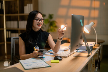 Poster - Asian businesswoman working late using computer and smartphone in office at night