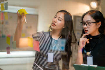 Poster - Businesswomen using sticky notes during a brainstorming session in the office