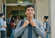 © Running opossum - Portrait of a smiling male university student adjusting his tie, ready for a successful day at school