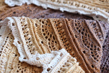 Poster - A stack of colorful crocheted scarves on a table, ideal for decoration or crafting.
