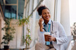 © Drazen - Happy black doctor talking on cell phone during her coffee break at clinic.