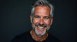© Happiness  Factory - Close-up portrait of a happy mature man smiling against a dark background. Perfect for advertising, marketing, or website banners.