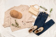 © Liami - Flat lay with women's trendy spring outfit on white sheet background, top view