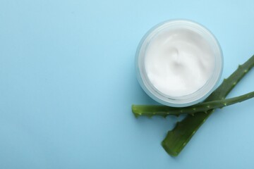 Wall Mural - cream and aloe leaves on light blue background, flat lay. space for text