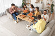 © Pixel-Shot - Group of young friends with beer eating pepperoni pizza at home party