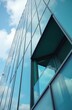 © Vadym - Close-up glass building with blue sky. Modern skyscraper facade of windows reflecting clouds. Commercial construction of corporate building with geometric design, metal steel frame, shiny surface.