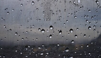 water drops on glass window with mosquito net against gray sky- 84189