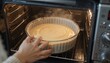 © Kahuni - She carefully places the cake batter into the oven and sets the timer