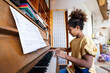 © NDABCREATIVITY - Happy little student girl is playing, learning and practicing the piano. Music abilities for kids