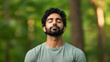 © UniqGraphicX - Young Indian man taking deep breath fresh air with copy space. Relaxation and well-being concept