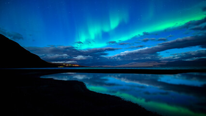 Wall Mural - northern lights dancing over calm lake in torne trask. abisko national park in north of sweden.